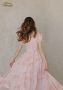 Back view of rose pink tiered ruffle dress with short sleeves and V-shaped seam