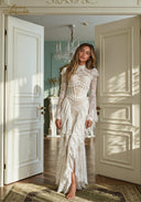 White lace evening gown with long sleeves and cascading ruffle layers