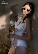 White one-piece swimsuit with pleated texture and high neck, side view
