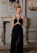 Black halter gown with beaded chest and fringe detail, flowing pleated skirt