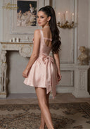 Rose satin mini dress with open-back straps and gathered bow at waist