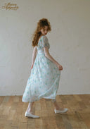 Light blue floral midi dress with puff sleeves, gathered waist, side view