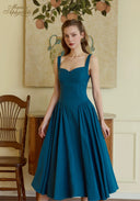 Teal blue suspender dress with square neckline and full pleated midi skirt.
