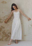 White midi slip dress with thin straps, lace bodice, and gathered waist skirt