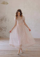 Light pink floral tea dress with lace neckline and puff sleeves; full skirt in relaxed standing pose.