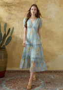Light blue floral midi dress with puff sleeves, tiered skirt, and V-neckline
