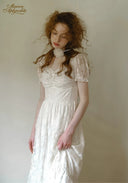 White lace dress with square neckline, short puff sleeves, gathered skirt