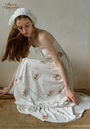 Secret Garden dress, white floral print with tiered ruffles; bonnet and close seated pose