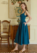 Teal blue suspender midi dress with square neckline and gathered waist pleats, front view.