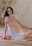 Light pink lace tea dress with puff sleeves and flowing, ruffled tiered skirt