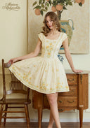 Cream linen dress with yellow floral embroidery, square neckline, flared skirt and fitted bodice.