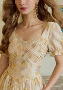 Close-up of cream floral dress bodice with lace trim and puff sleeve cuff