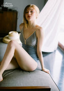 Blue one-piece swimsuit with thin straps and fitted skirt panel