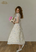Floral tea dress in light tone with fitted waist and softly ruffled hem