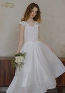 White lace dress with V-neckline, ruffled sleeves, gathered waist and full skirt
