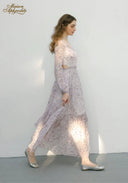 Lilac floral midi dress in profile view with long sleeves and tiered skirt