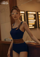 Navy one-piece swimsuit with square neckline and shoulder ties, brown waist belt