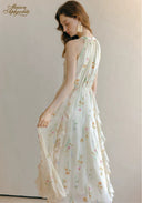 Back view of floral sleeveless midi dress with gathered tiered skirt and open-back styling