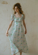 Light blue floral midi dress with puff sleeves and gathered waist, side view