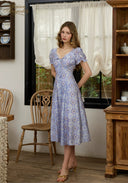 Light blue floral midi dress with puff sleeves and lace-trim square neckline, side view