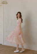 Rose pink tiered flared midi dress with short puff sleeves and lace V-neck, side view