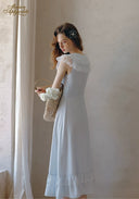 White lace off-shoulder style midi dress with ruffled trim, side profile
