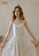 White lace-trim slip dress with spaghetti straps and tiered, flared skirt