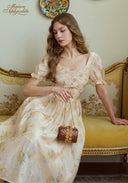 Cream floral puff sleeve midi dress with gathered skirt and small round bag
