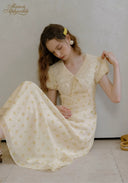 Lace tea dress in pale yellow with V-neck lace bodice and full gathered skirt, seated pose