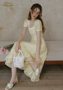 Romance dress in pale yellow with lace-trim square neckline and short puff sleeves, sitting