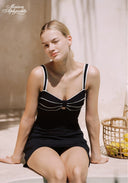 Black swim dress with white-trim bow and sweetheart neckline, thin straps