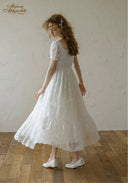White lace dress with square neckline and puff sleeves, flared midi skirt.