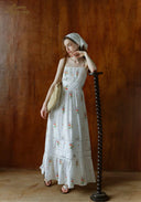 Floral tiered maxi sundress with thin straps and tiered ruffle skirt, with woven bag