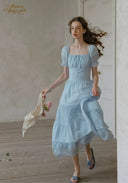 Light blue puff-sleeve lace dress with square neckline, tiered skirt and fitted bodice.