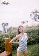 Blue-and-white striped one-piece swimsuit with thin straps, side profile