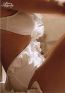 White ruffled swimsuit close-up with textured eyelet fabric panels