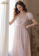Light pink floral tea dress bodice close-up with lace yoke, puff sleeves, and gathered skirt.