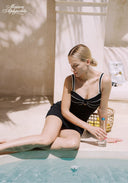 Black swim dress with white-trim straps and bust bow detail, short skirt
