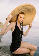 Black one-piece swimsuit with halter straps and sparkle dots, gathered neckline.
