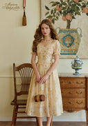 Woman in a vintage-style dress standing in a room with decorative elements and furniture.