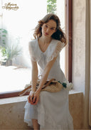 White lace V-neck dress with ruffled short sleeves and layered skirt hem