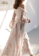 Floral tiered dress in pale pink with ruffled shoulder trim, back view walking