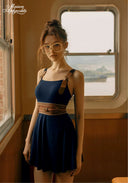 Navy swimdress with square neckline and shoulder tie straps, tan braided waist belt