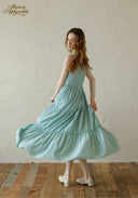 Light blue tiered midi dress with lace-trim neckline and spaghetti straps, flared gathered skirt