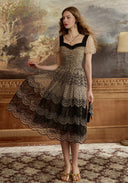 Lace mesh dress with dark lace trim, puff sleeves, fitted waist, and scalloped tiered skirt