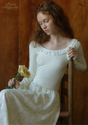 White ballet dress with fitted bodice, long sleeves, and ruffled, lace hem