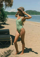 Green checkered one-piece swimsuit with scoop neckline and thin straps, side view.