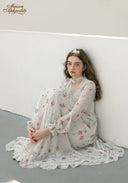 Floral midi dress with long sleeves and tiered hem, seated pose