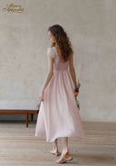 Pale pink dotted midi dress with ruffled neckline, lace front, and gathered skirt