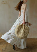 Secret Garden dress with floral print, tiered skirt; straw round bag in hand